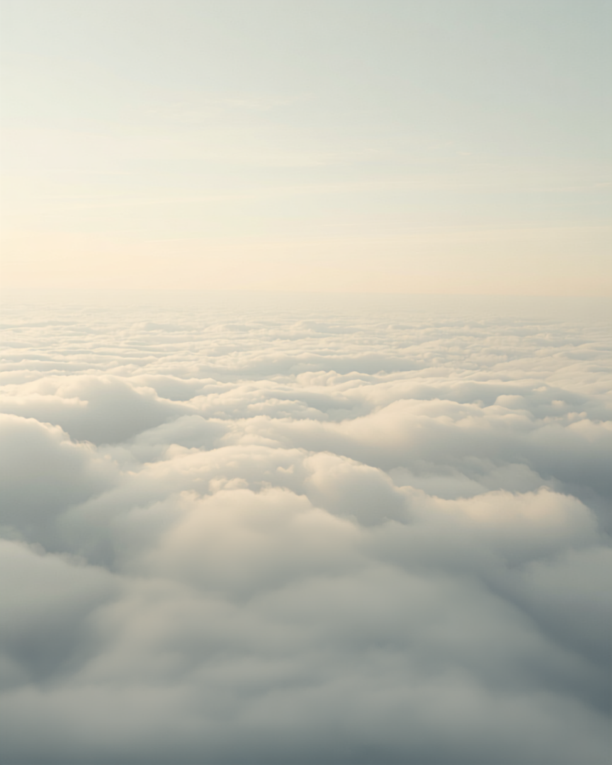 Snowy mountain peak rising above a sea of clouds at golden hour.